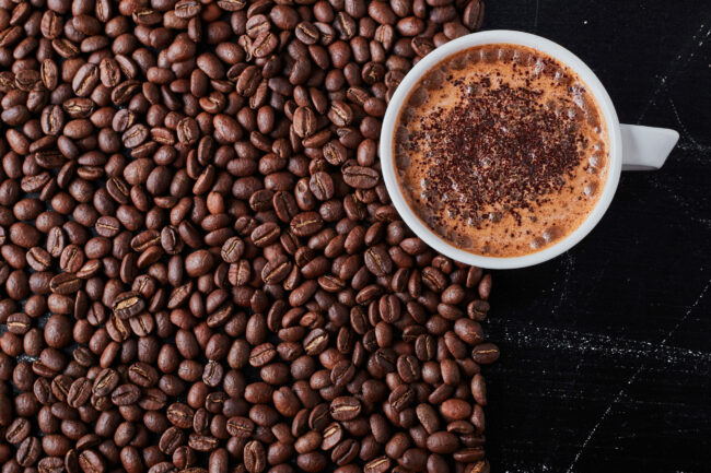 A cup of coffee on brown beans